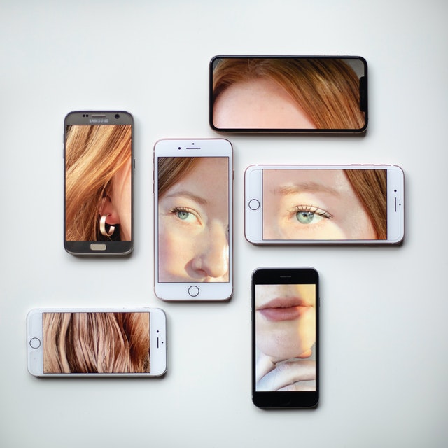 The pieces of a face on the screen of 6 distinct smartphones