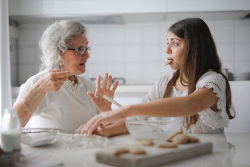 Grandmother and her granddaughter preparing cookies together