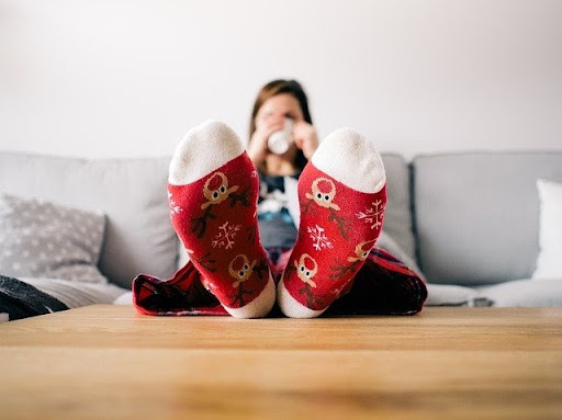 Woman in the bed sipping coffee in Christmas socks