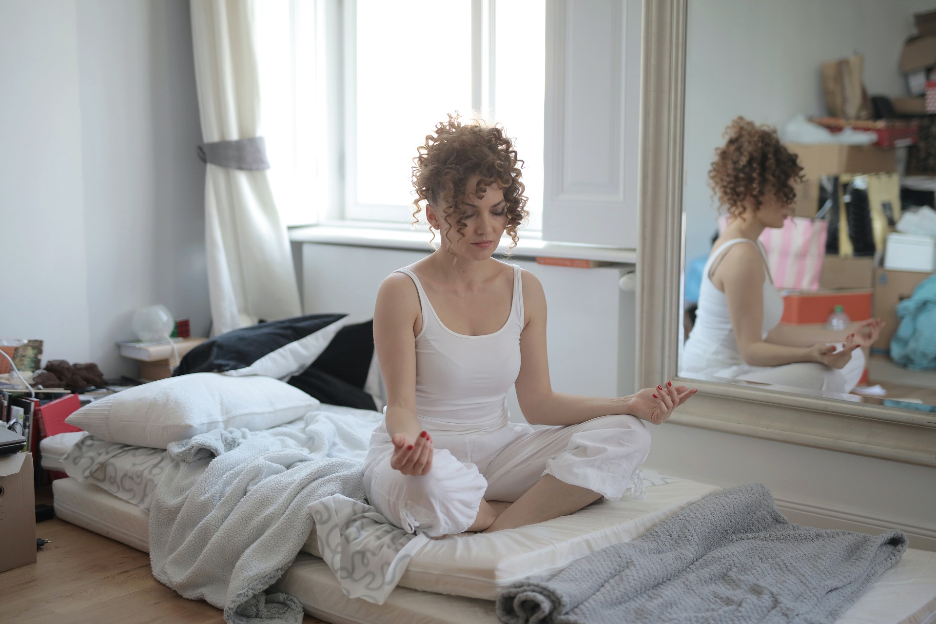 Woman meditating in a messy little room
