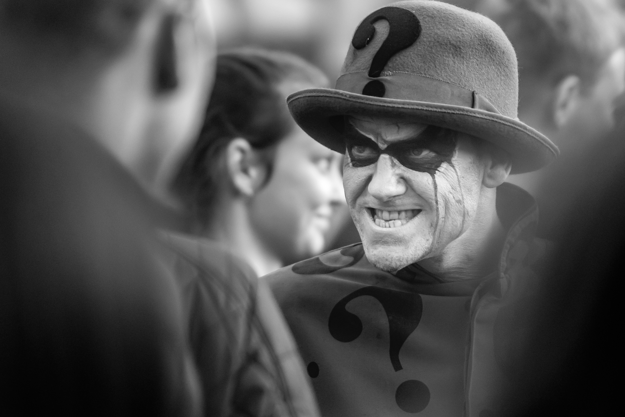 Infamous Riddler of DC Comics grins under bowler hat with large question mark in front.