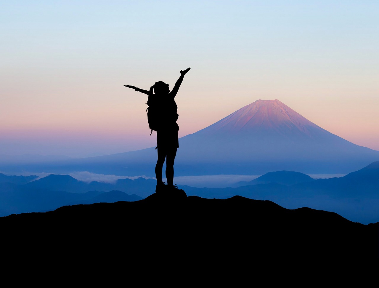 Silhouette of a girl at the top of the mountain