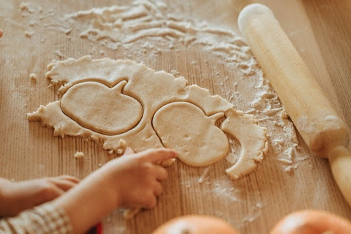 Little children’s hands preparing thanksgiving cookies