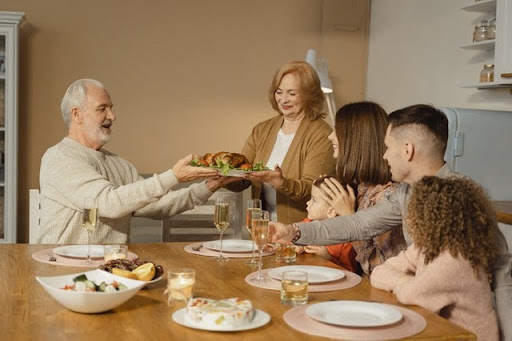 Family members around the table with Thanksgiving turkey