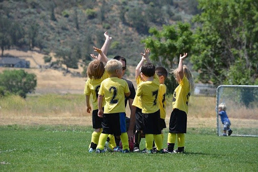 A group of children in yellow T-shirts on the football field